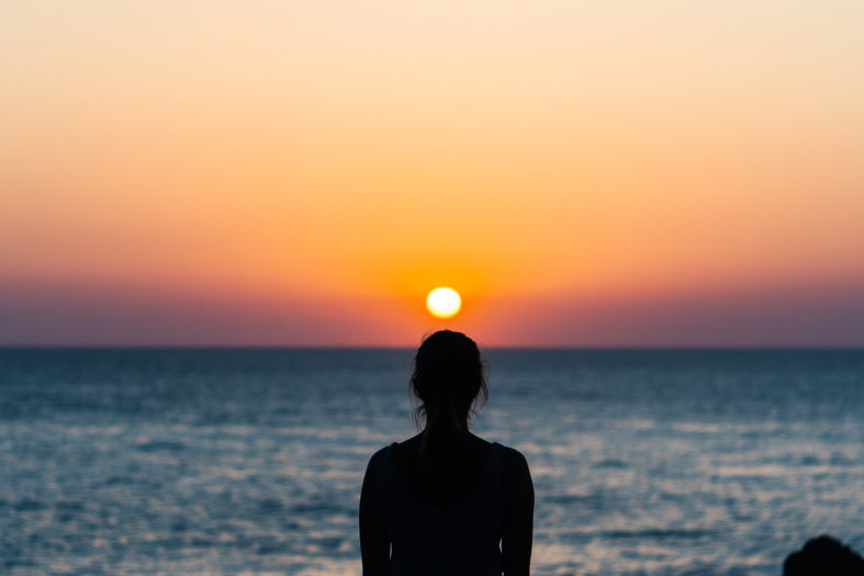 Silhouette of a person at sunset by the sea