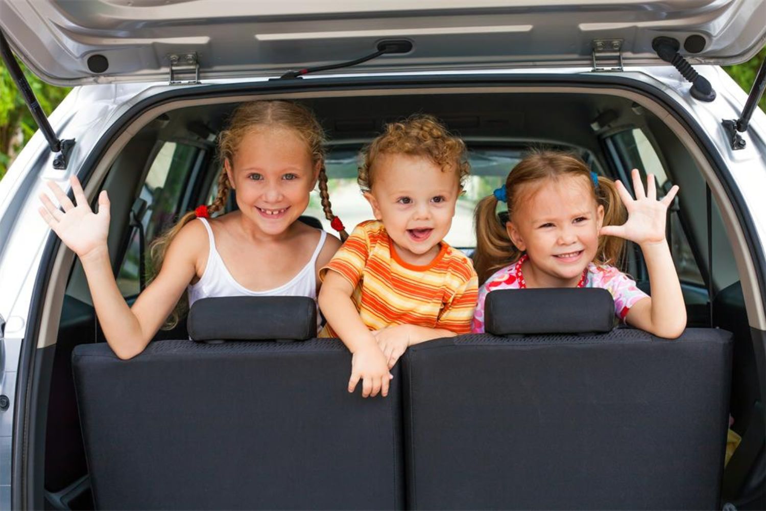 boy and girls sitting in the backseat and greeting 