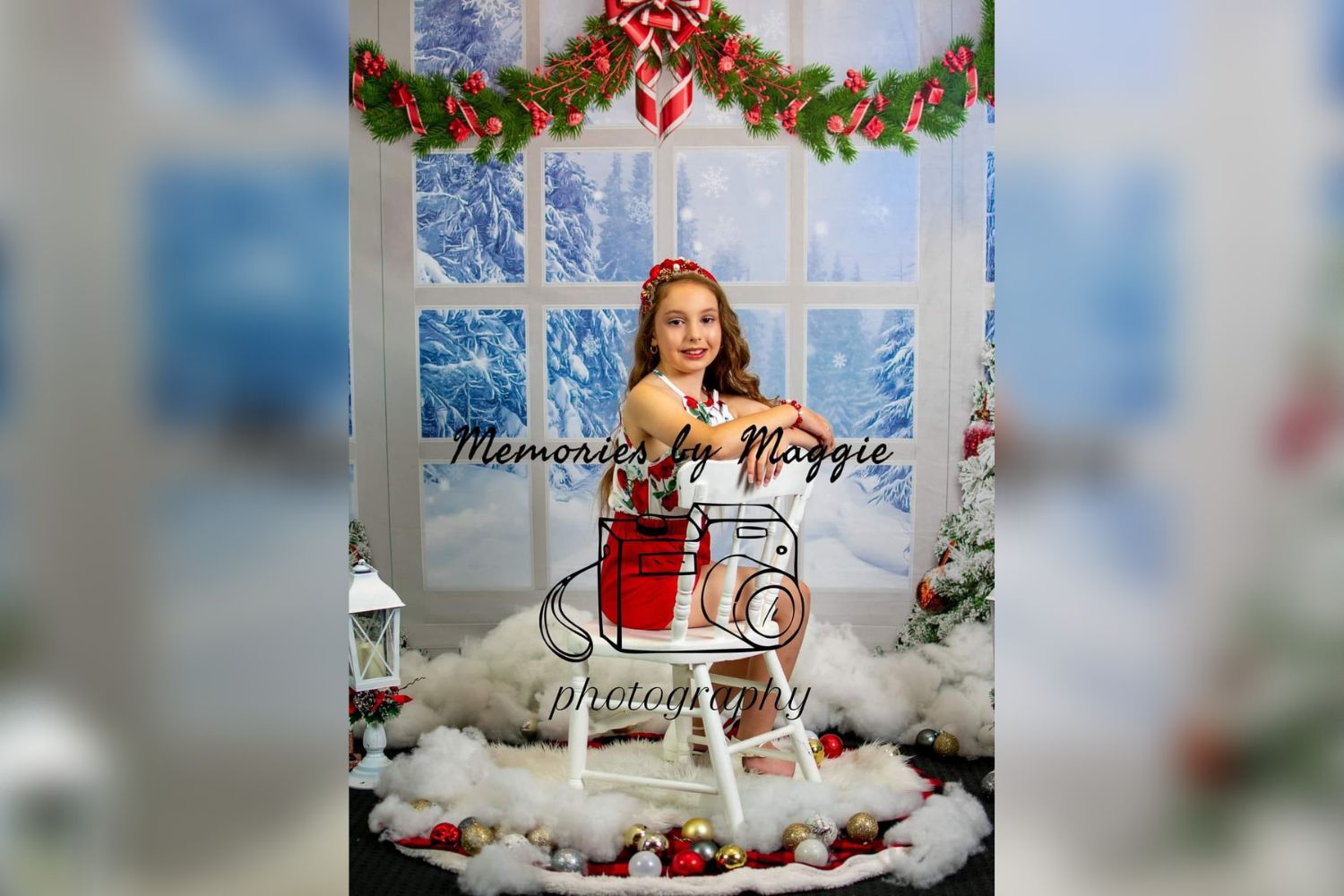 girl sitting beside a snowy window decorated with Christmas bells banner