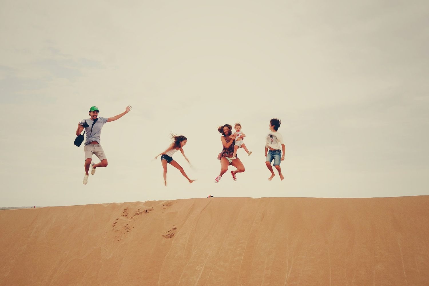family members jumping high on the desert