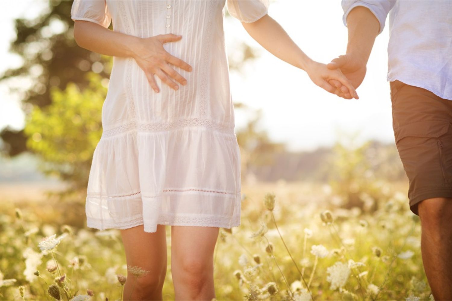 couple maternity photo of walking together by holding hands