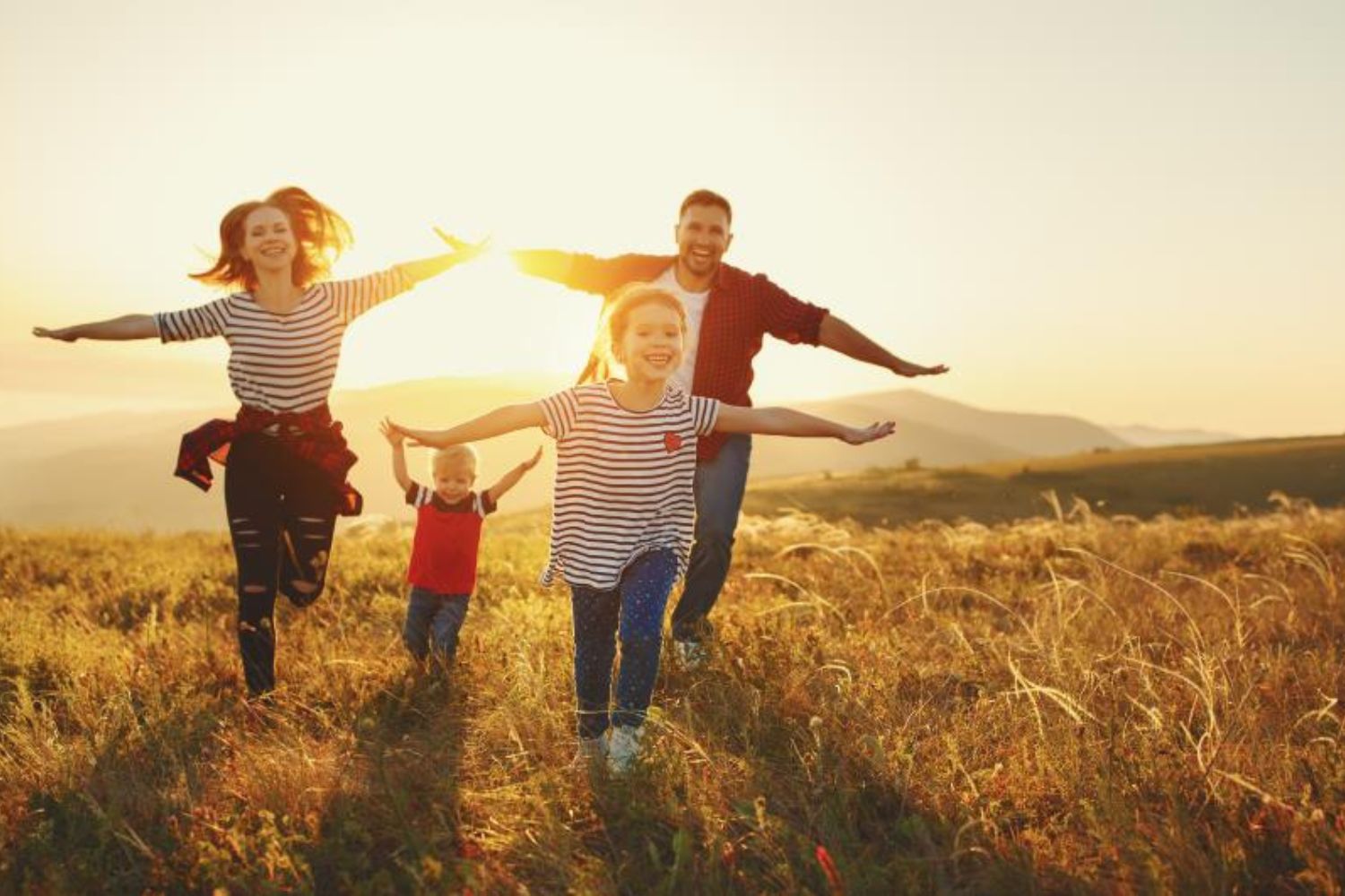 parents and kids running on the grassland with wide arm