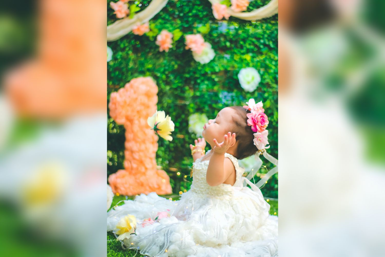 a baby girl's 1st year birthday with flower wall 