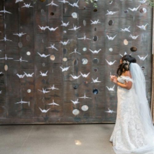 a bride taking photo in front of Origami Backdrop