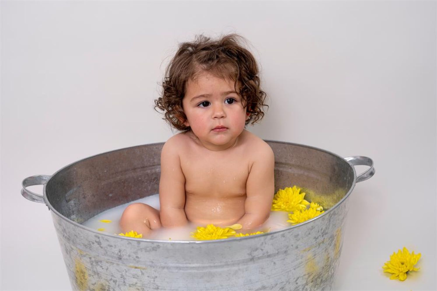 baby in milk bath with flowers in 