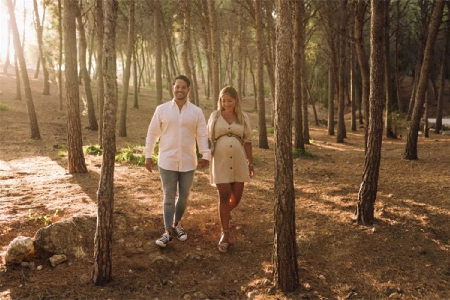 couple maternity photos in the woods