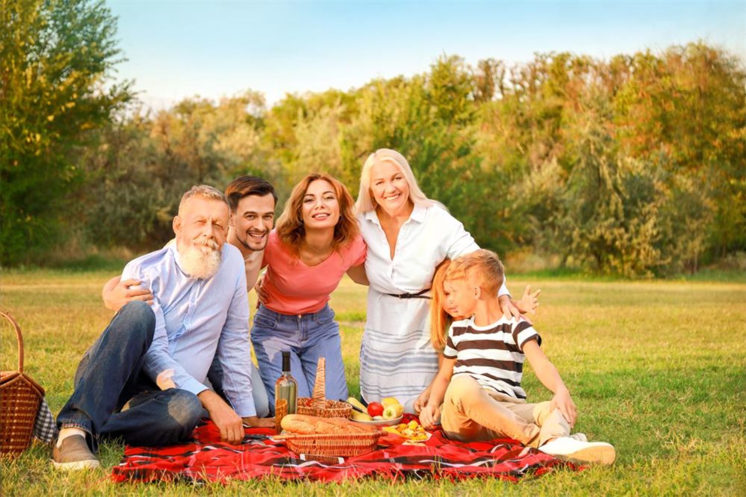 family taking photo when having picnic on the grassland