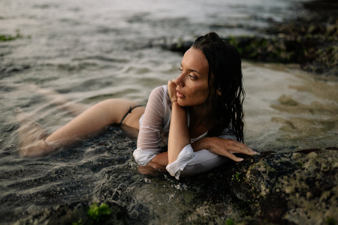 Woman lying in the shallow waters on the beach