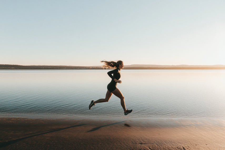 Woman running on the beach at sunrise