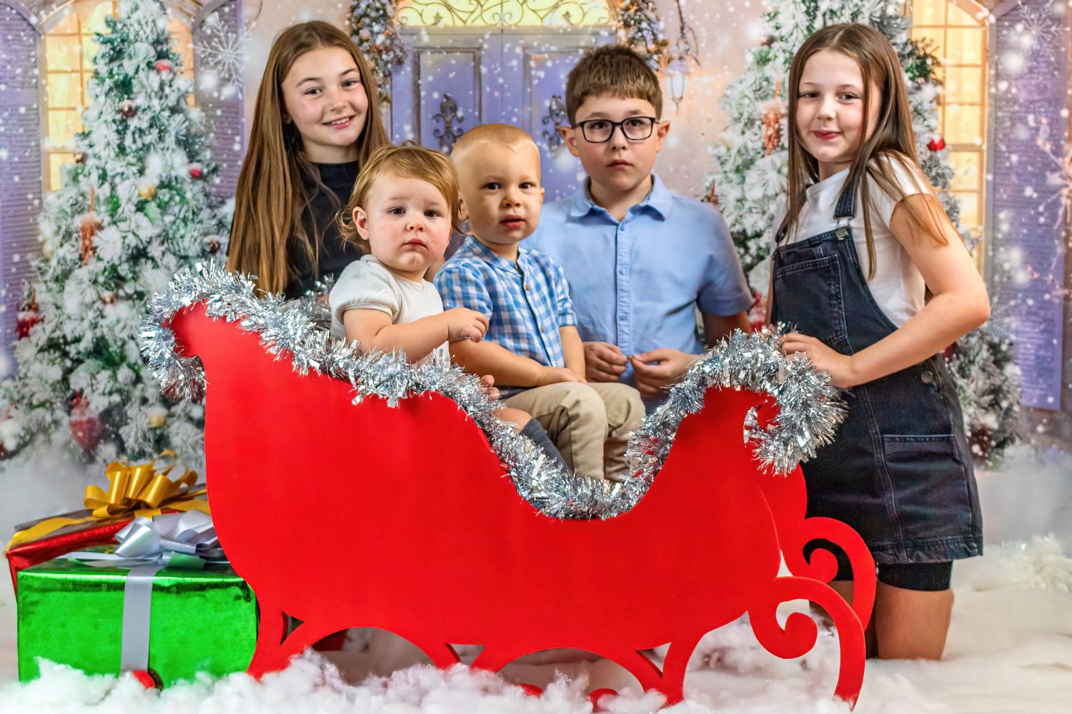 siblings taking photo with a sleigh