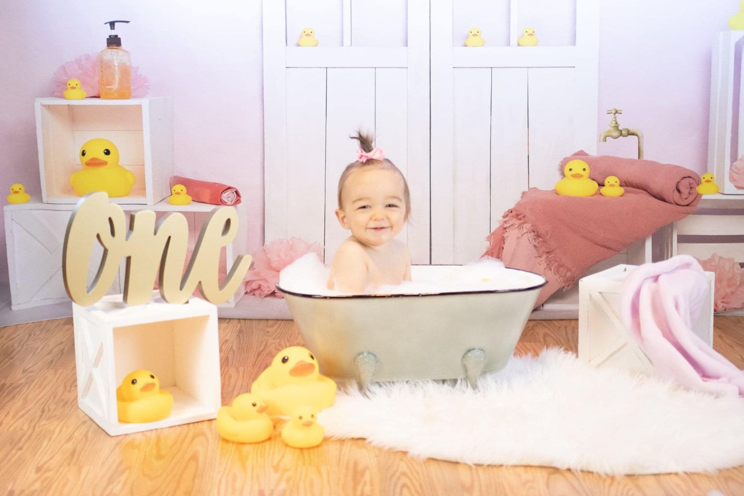 baby girl's taking bath with bubbles and ducks