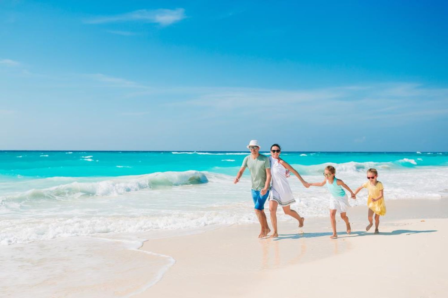 family walking on beach by holding hands