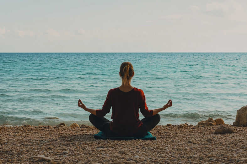 Meditating on a pebble beach by the ocean