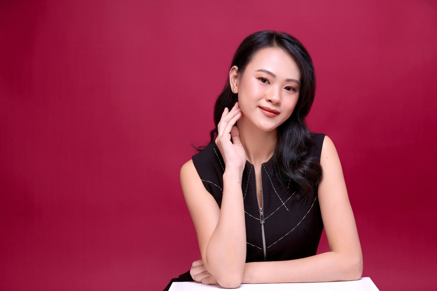 a woman is taking a sitting photo by leaning on the desk