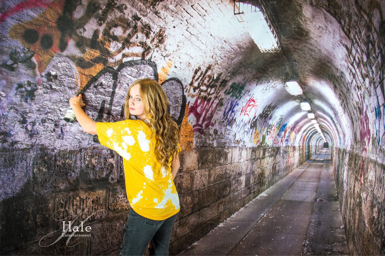  a girl standing in front of a graffiti tunnel
