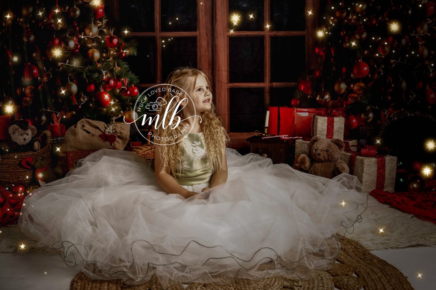 little girl wearing vintage dress beside a lighted Christmas tree
