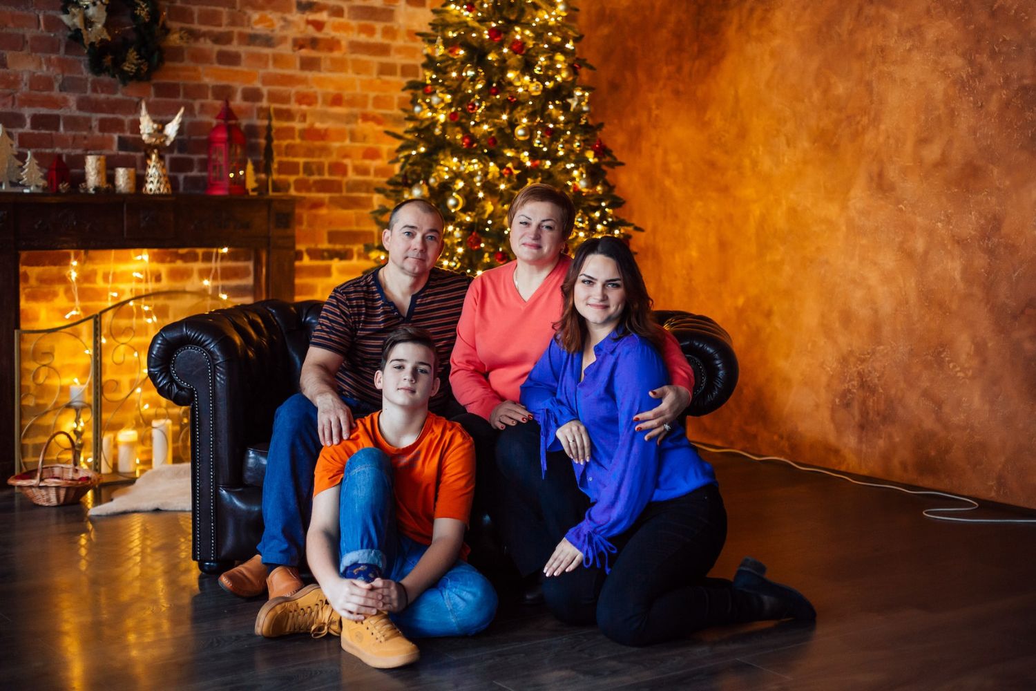 family taking Christmas photo  in front of the fireplace and Chritsmas tree