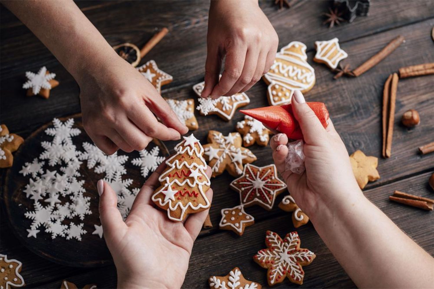 two guys decorating gingerbread in hand