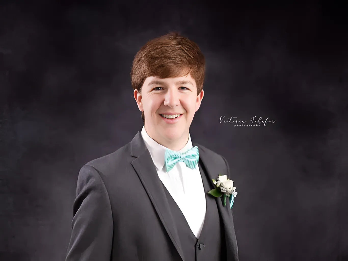 A young man dresses in a sharp suit and bow tie.