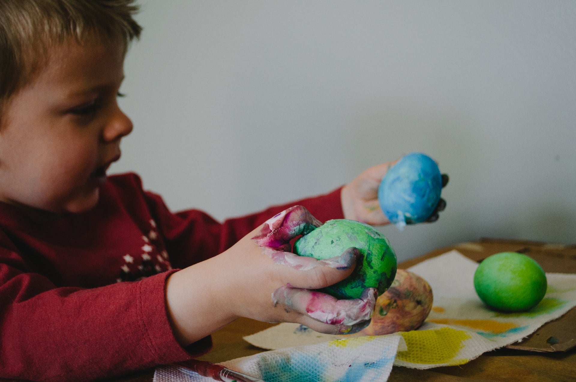 a little boy coloring Easter egg