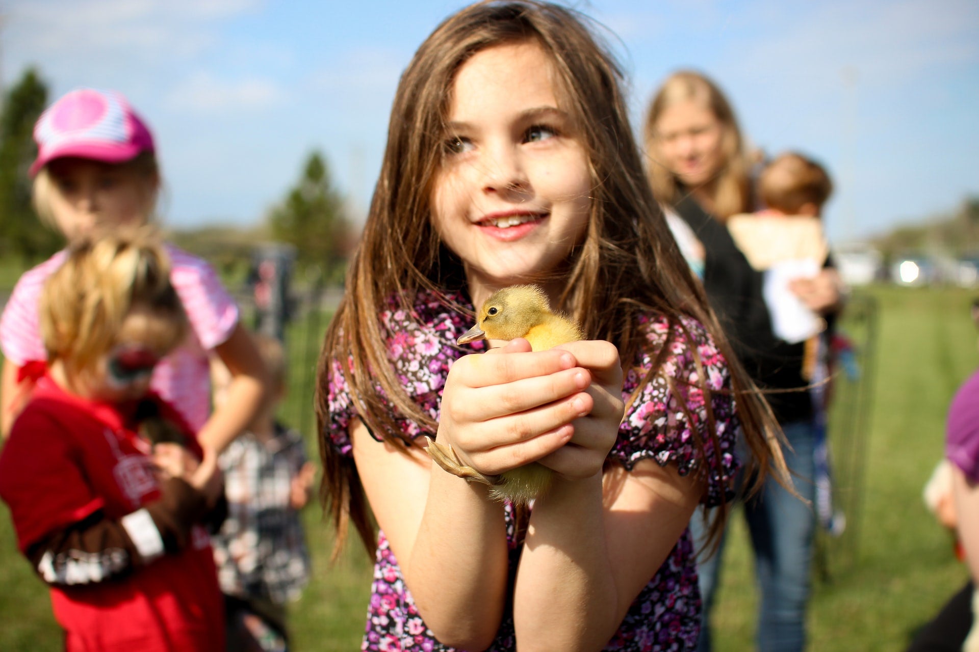 a girl holding a ducky in fron of her family members