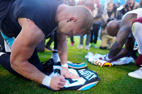 Christian McCaffrey signs jersey for fan big arms