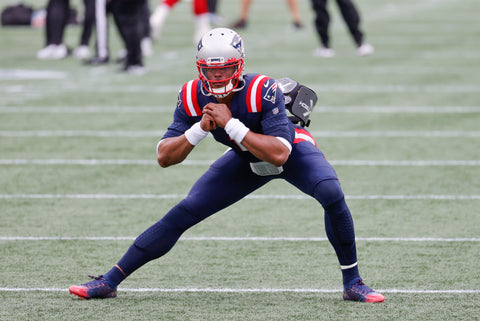 Cam newton on pitch with helmet and blue red kit