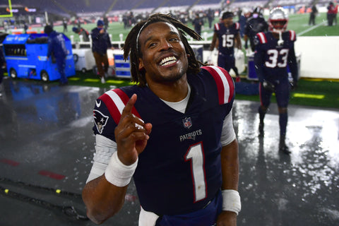 Cam newton smiles at camera in ble and red kit