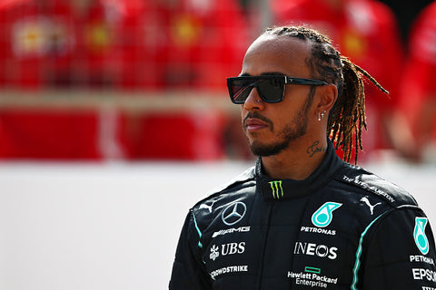 Lewis hamilton with pony tail and sunglasses and F1 jacket 