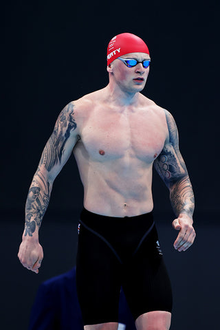 Adam peaty by pool red swim cap