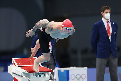 Adam peaty dives into pool red swim cap