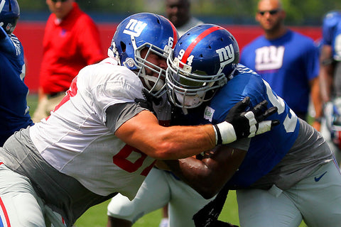 Justin Pugh in tackle on pitch blue helmets