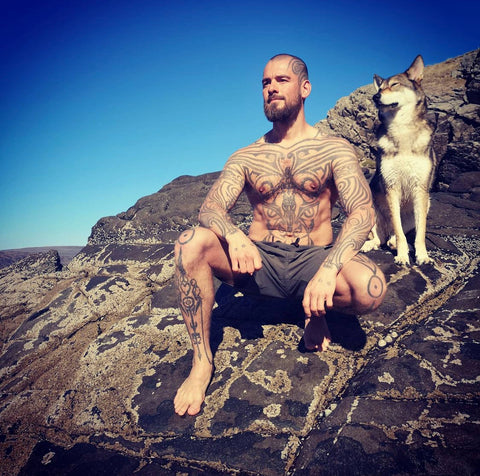 topless philipp Tanzer with dog sat on rocks 