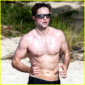 Robert Pattinson runs on the beach topless