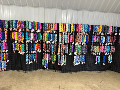 Booth with a dark background and brightly colored yarn
