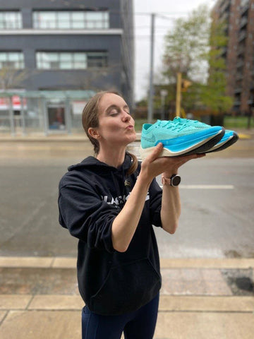 A runner pretending to kiss a pair of Nike running shoes | Nike shoes for sale at BlackToe Running | Toronto, Canada