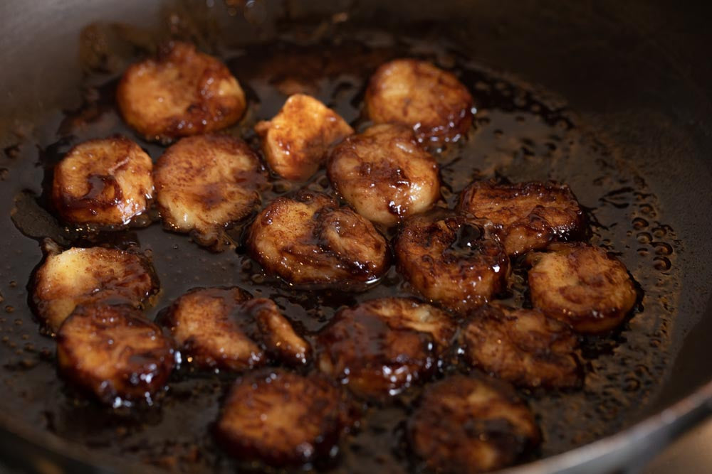 Image showing bananas being fried in ShortHive Cacao (chocolate) honey in a pan.