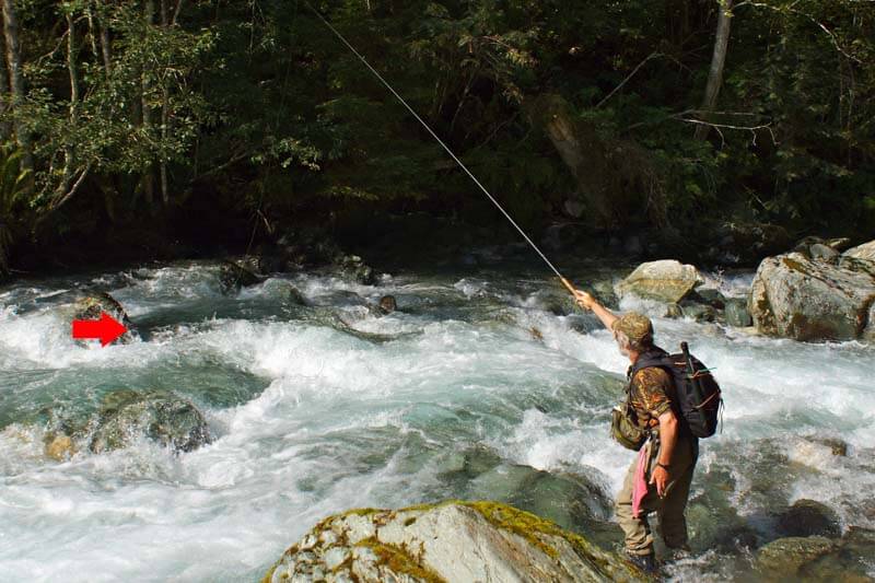 Pescare una grossa mosca secca con Tenkara in un ruscello alpino austriaco dietro un masso
