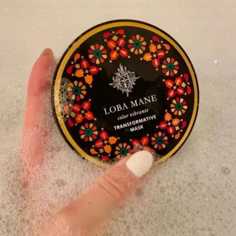 Loba Mane's Transformative Hair Mask being held in a bubble bath