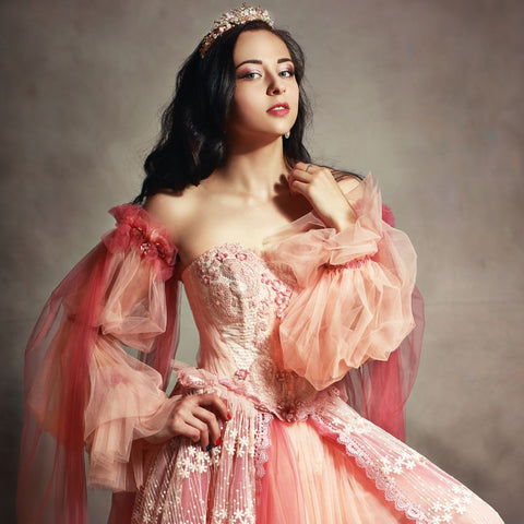 Woman wearing a pink gown and a tiara.