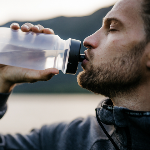 Man with a beard drinking out of a water bottle.