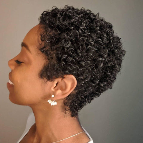 Woman with curly hair and pixie hair cut turned to the side and her hair is styled with Loba Mane's Styling Cream.