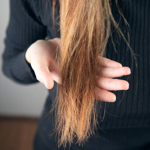 Person showing their frizzy, damaged hair.