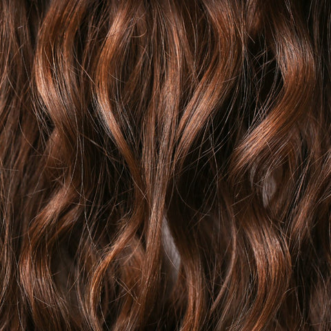Close-up image of light brown wavy hair with highlights.