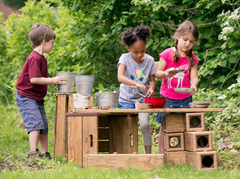 children making their own table with outlast blocks and crates for their outdoor classroom play yard