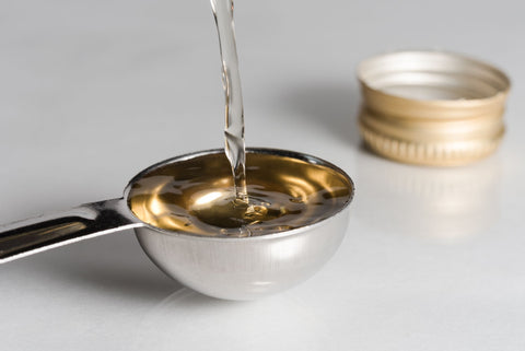 olive oil being poured into a spoon