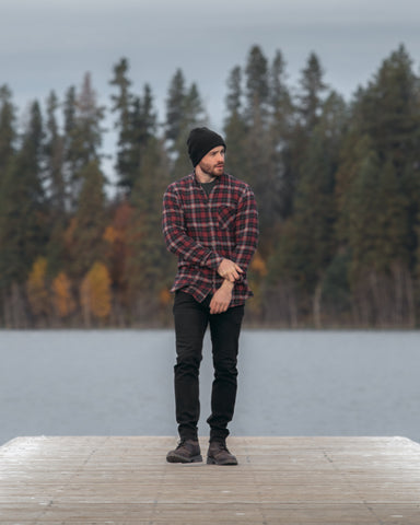 a man dressed for fall weather wearing plaid, a toque and DUER jeans