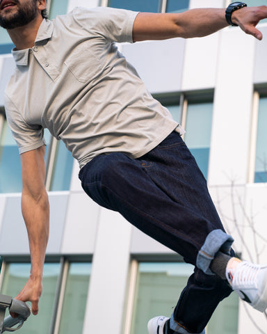 sportly dressed man wearing DUER jeans jumping over railing
