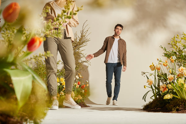 a man and woman standing among planters wearing DUER outfits