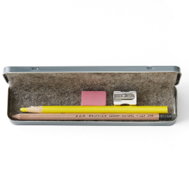 Gray aluminum pencil tin set lays open with wool liner and a pencil, wax peel highlighter, sharpener, and eraser inside against a white background.